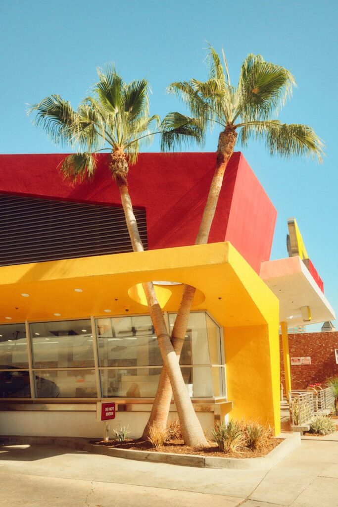 Colorful In-N-Out Burger restaurant facade with palm trees in Los Angeles.