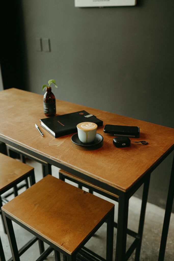 Coffee, notebook, and accessories on table.