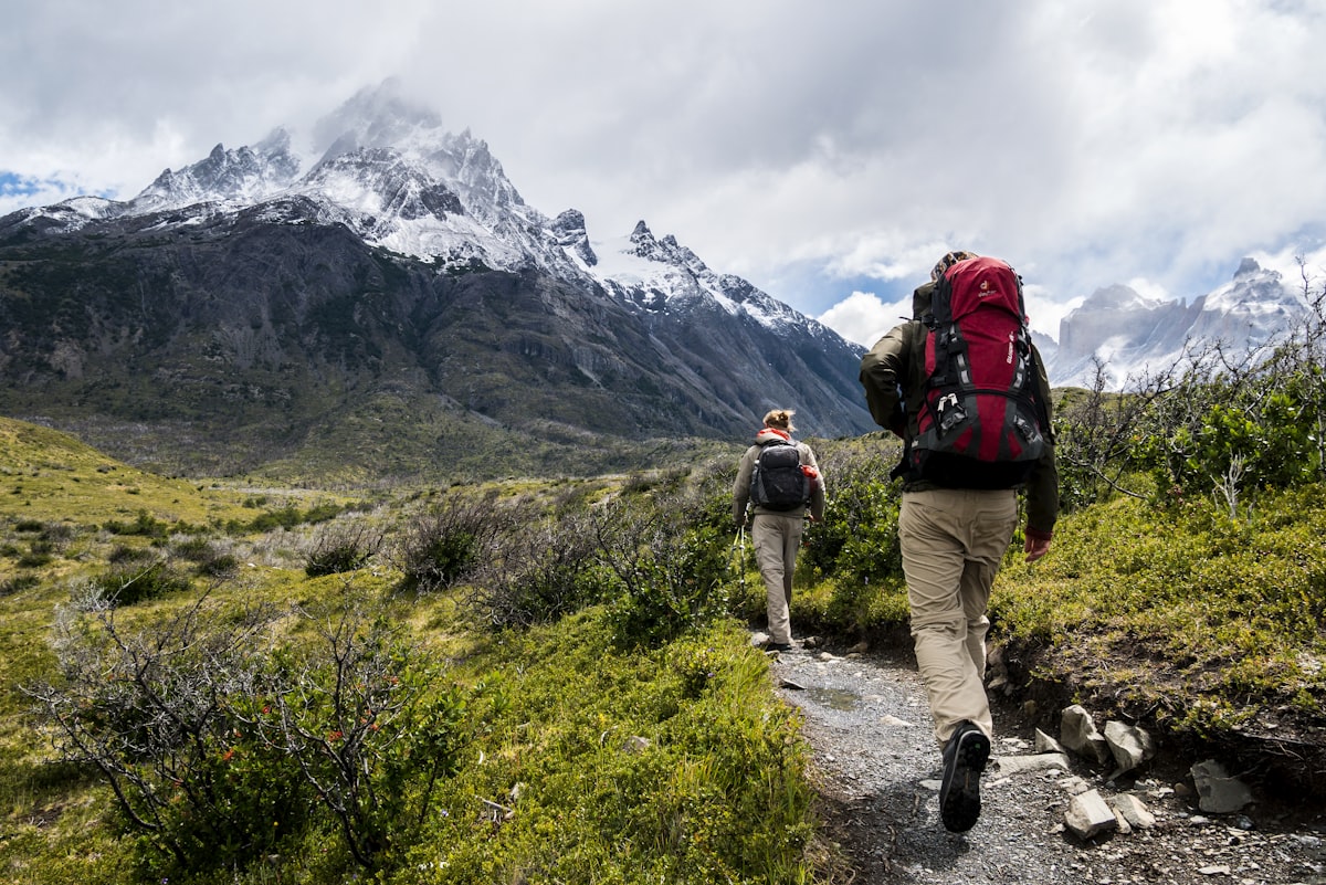 Hikers carrying backpacks along a mountain trail