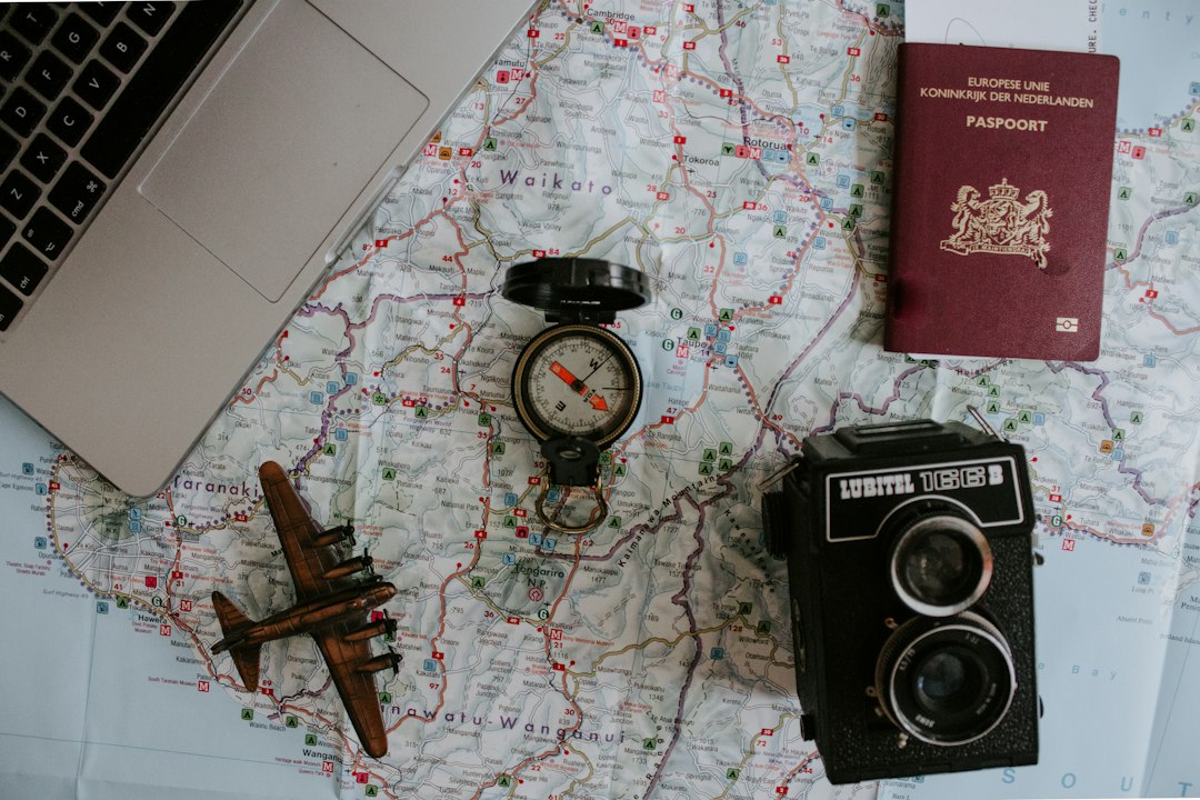 Travel planning desk with laptop, passport and booking notes