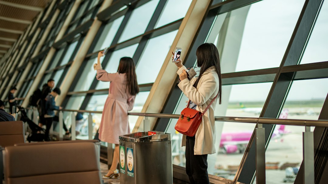 Travelers using a phone at an airport terminal