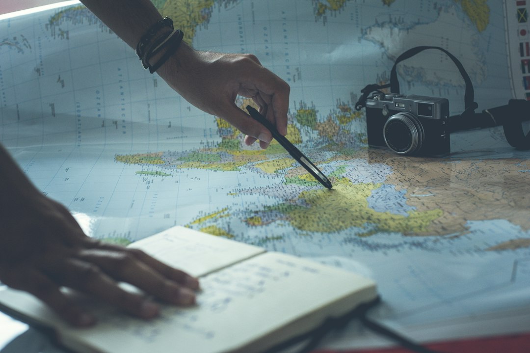 Writing travel plans beside a map and itinerary notes
